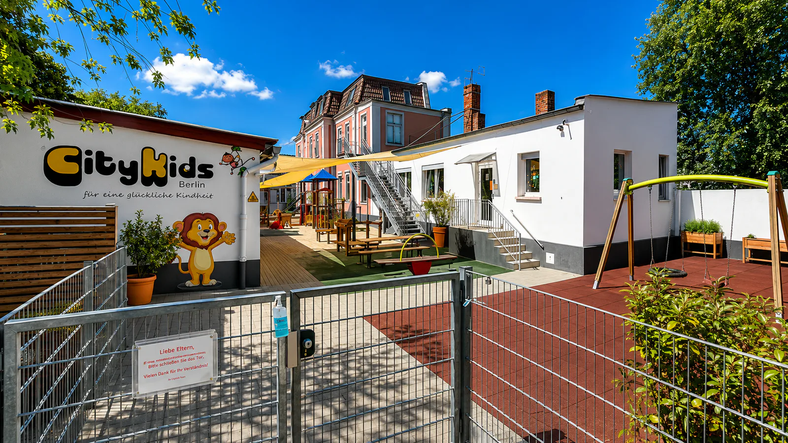 Außenbereich der CityKids-Kita Dschungelbande mit Spielgeräten und Sonnensegeln